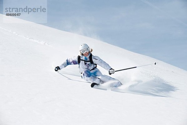 Österreich  Kleinwalsertal  Junge Frau beim Skifahren und Lächeln