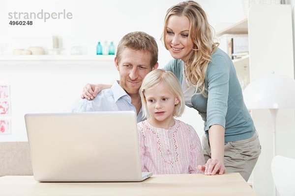 Deutschland  Bayern  München  Familie mit Laptop  lächelnd