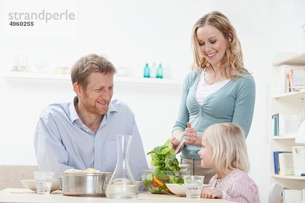Deutschland  Bayern  München  Eltern und Tochter beim Abendessen  lächelnd