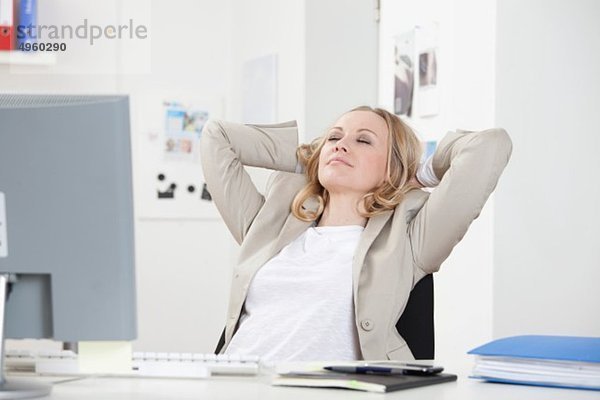 Geschäftsfrau entspannt im Büro  Augen geschlossen