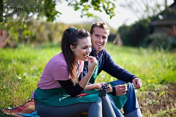 Kroatien  Baranja  Junger Mann und Frau essen Trauben und lächeln