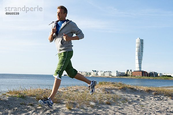 Ein Mann joggen am Strand  Malmö  Schweden.