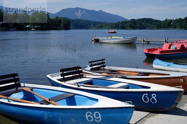 Europa  Deutschland  Bayern  Oberbayern  Bootsliegeplatz im See mit Berg im Hintergrund