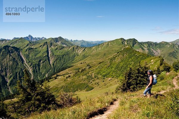 Österreich  Vorarlberg  Allgäuer Alpen  Frau stehend mit Rucksack