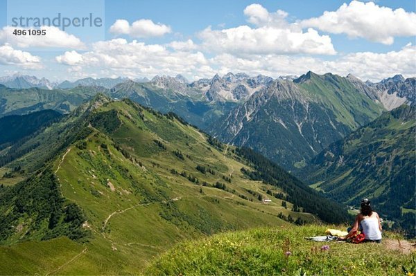 Österreich  Vorarlberg  Frau sitzend bei Blickrichtung