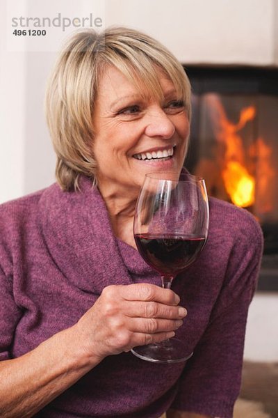 Seniorin mit Weinglas  lächelnd