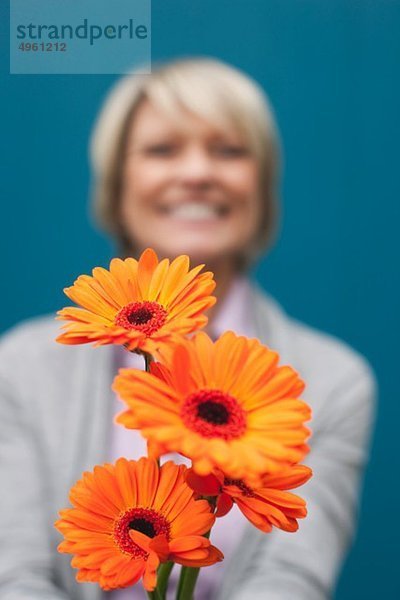 Seniorin mit Blumenstrauß  lächelnd