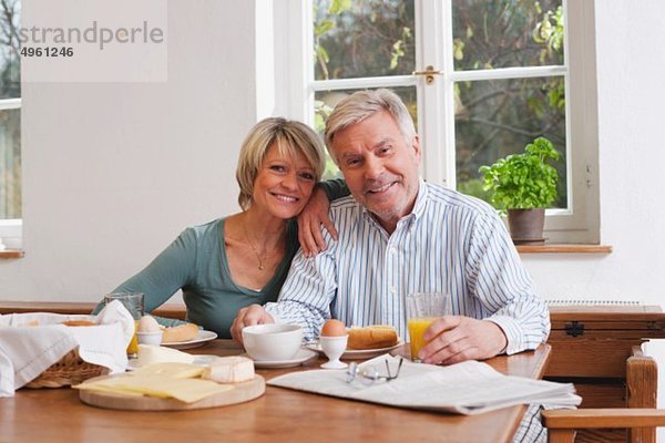 Deutschland  Kratzeburg  Seniorenpaar beim Frühstück  lächelnd  Portrait