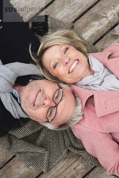 Deutschland  Kratzeburg  Seniorenpaar auf Strandpromenade liegend  lächelnd  Portrait