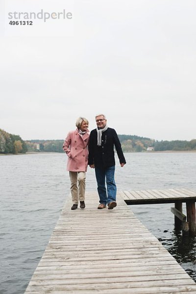 Deutschland  Kratzeburg  Seniorenpaar auf Strandpromenade  lächelnd