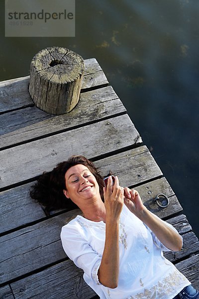 Eine Frau auf eine Mole an einem See  Schweden.