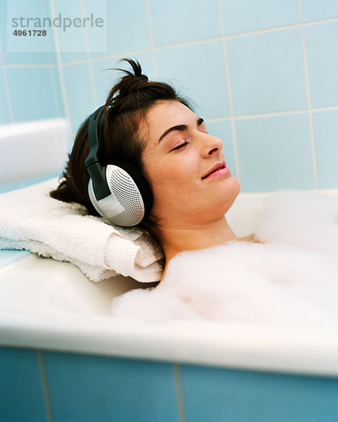 Mitte erwachsen frau in Badewanne  entspannende Musik zu hören
