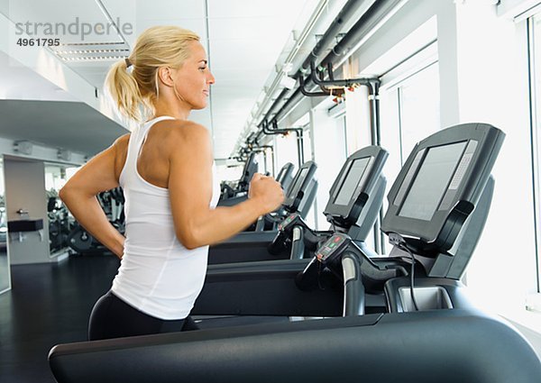 Frau beim training auf Laufband in Fitness-Studio