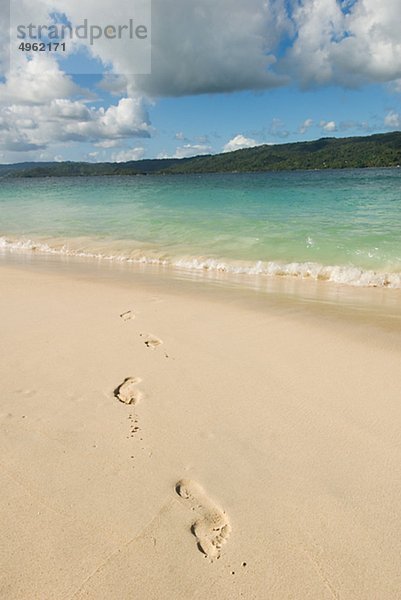 Fußabdrücke auf Sand am Strand