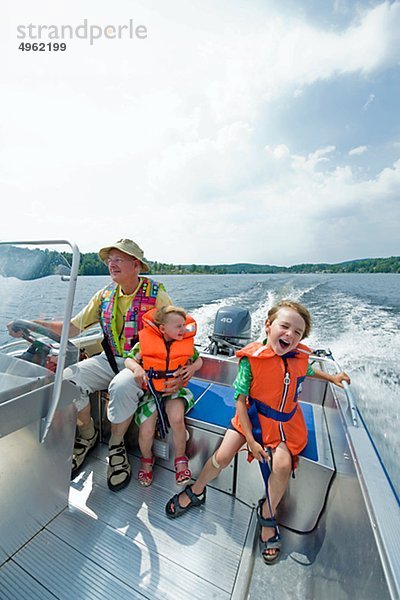 Großvater Motorboot mit jungen und Mädchen