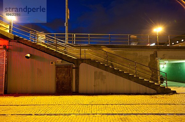 Beleuchtete Treppe in der Nähe von Straßenbahn in Stadt