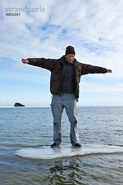 Junger Mann Standing on Ice Floe im Meer