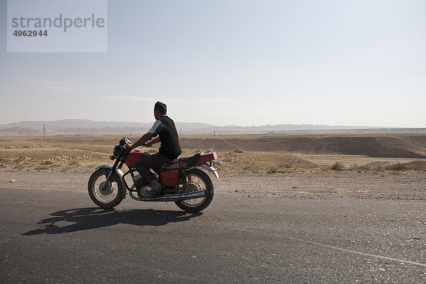 Usbekistan  Mann auf dem Motorrad entlang der ehemaligen Seidenstraße