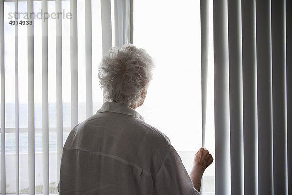 Seniorin mit Blick aus dem Fenster