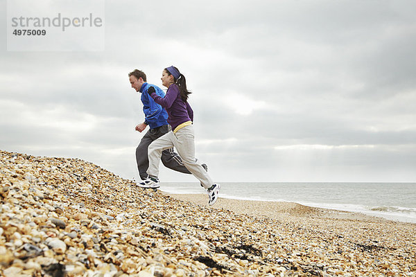 Paar-Training am steinigen Strand