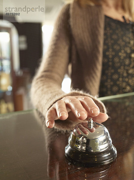 Nahaufnahme einer Frau  die in einem Hotel klingelt.