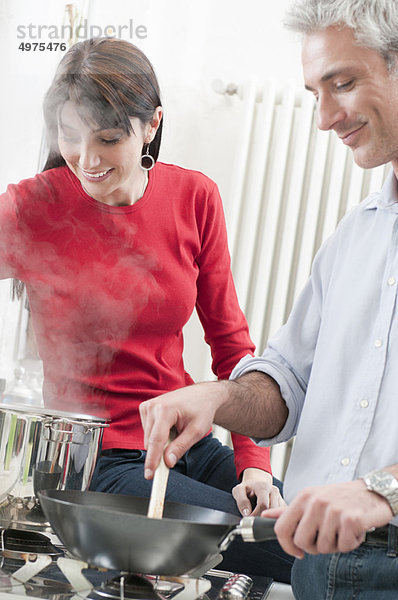 Glückliches Paar kocht zusammen in der Küche