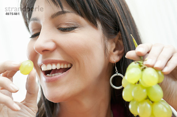 junge Frau junge Frauen Bündel Weintraube essen essend isst