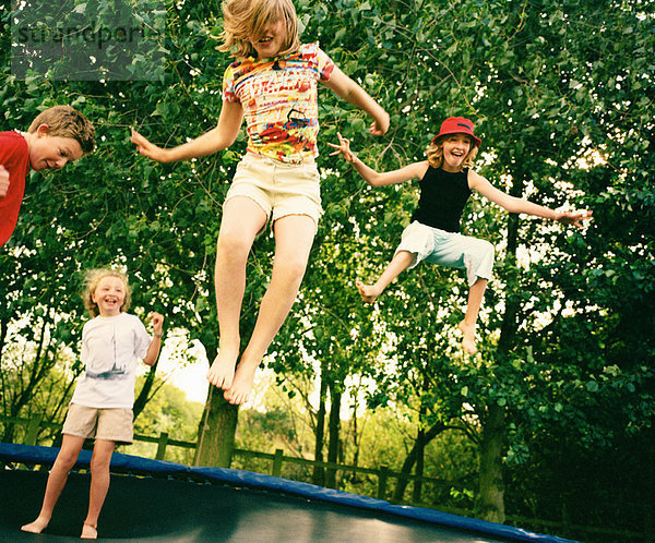 4 Kinder springen auf Trampolin