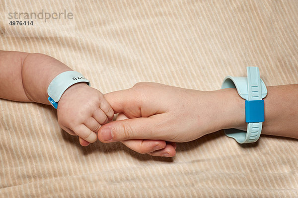 Neugeborene und Mütter mit Krankenhausarmbändern