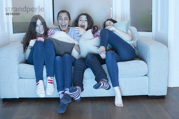 Teenager-Mädchen beim Fernsehen auf dem Sofa