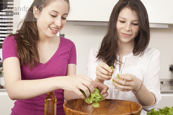 Teenagermädchen bereiten Salat in der Küche zu