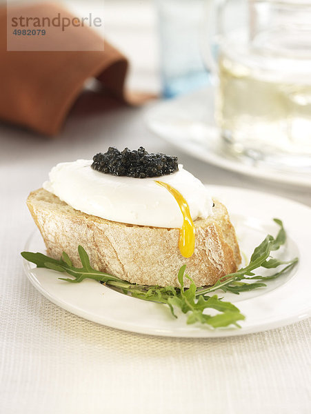 Pochiertes Ei und Kaviar auf einer mundgerechte Scheibe Brot