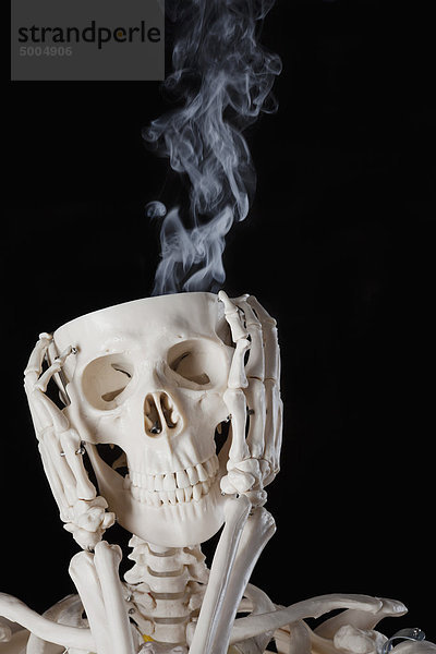 Ein Skelett mit Rauch aus dem Schädel.