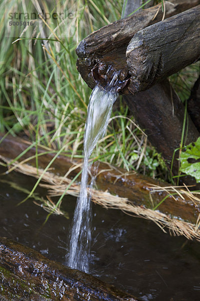 Wasser  das aus einem hölzernen Abfluss fließt