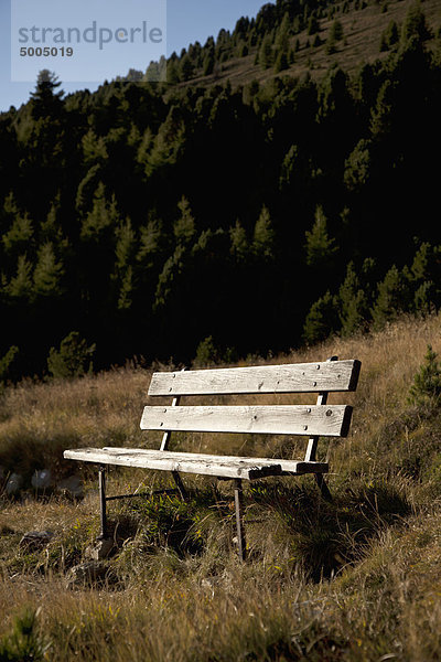 Eine hölzerne Sitzbank in einer Bergkulisse