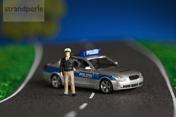 Ein Diorama einer Miniatur-Polizistenfigur neben einem Miniatur-Polizeiwagen