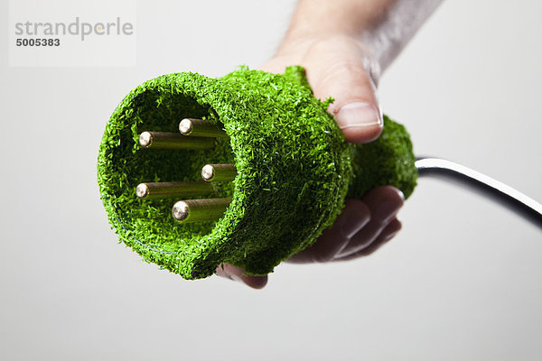 Energiesparendes Stromkabel mit grünem Gras bedeckt