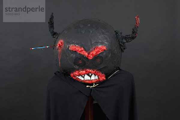 Dunkle Halloween Maske und schwarzer Umhang.