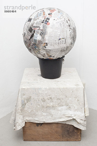 Papier Mache Ball auf Eimer auf Karton.