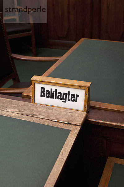 The German word  Beklagter  for defendant on a sign  among some tables and chairs.