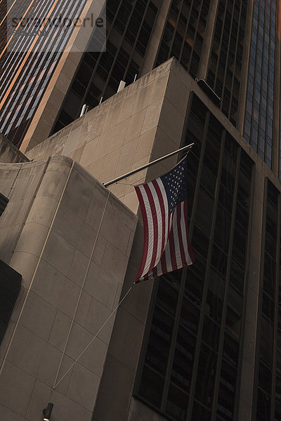 Eine amerikanische Flagge  die an einem Wolkenkratzer hängt  Manhattan