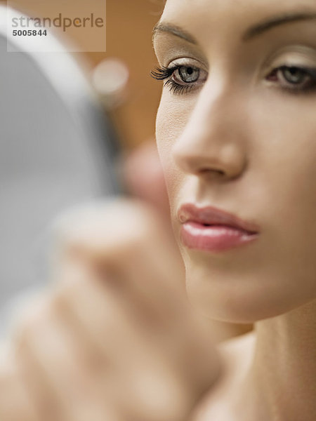 Eine Frau  die in den Spiegel schaut  eine Nahaufnahme von Gesicht  Mund.