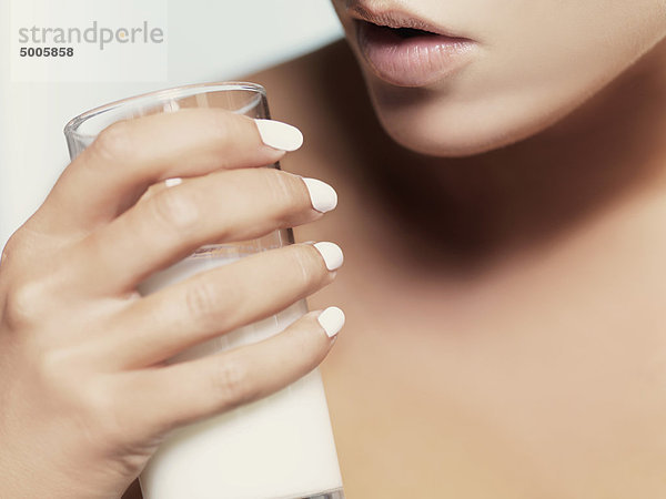 Eine Frau mit einem Glas Milch  Nahaufnahme von Lippen und Hand  Mund.