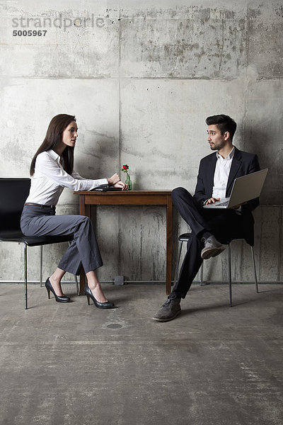 Ein Geschäftsmann und eine Geschäftsfrau in einem modernen Büro.