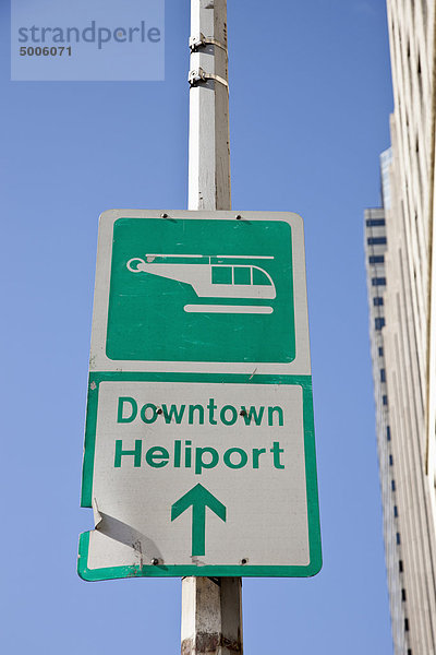 Schild'Downtown Heliport' mit Richtungspfeil