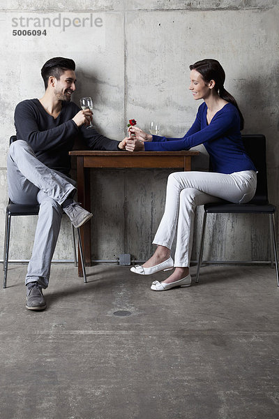 Ein Paar  das ein Glas Wein in einem Restaurant genießt.