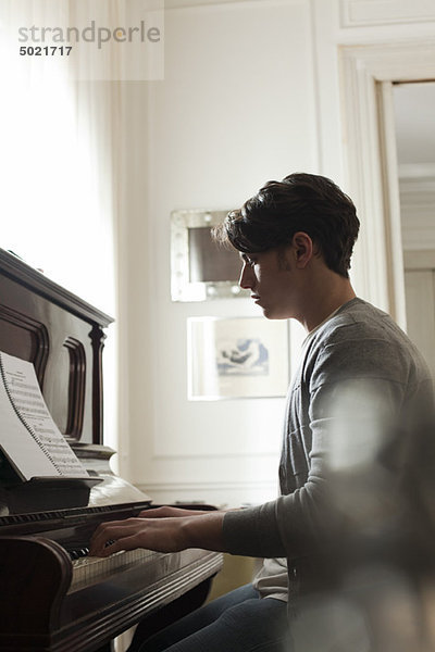 Junger Mann spielt Klavier