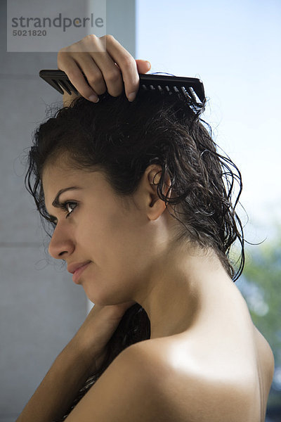 Frau kämmt nasses Haar