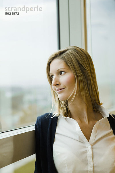 Frau schaut aus dem Fenster  Porträt