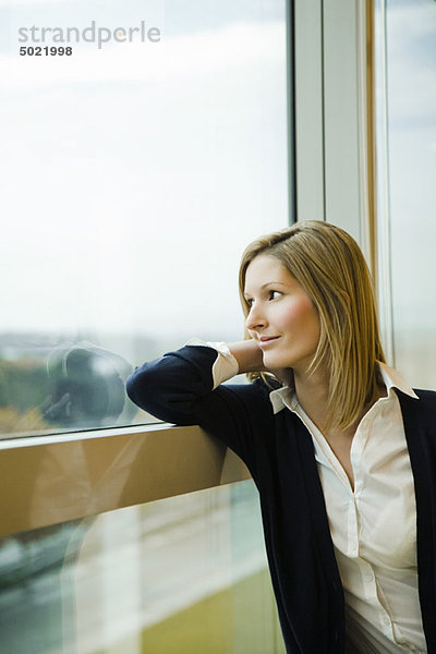 Frau schaut aus dem Fenster  Tagträumen